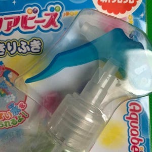 May include: A clear plastic Aquabeads spray bottle with a blue trigger. The packaging is blue and green with Japanese text and the Aquabeads logo. The package also has a red and white sticker that says "2017 New Release".