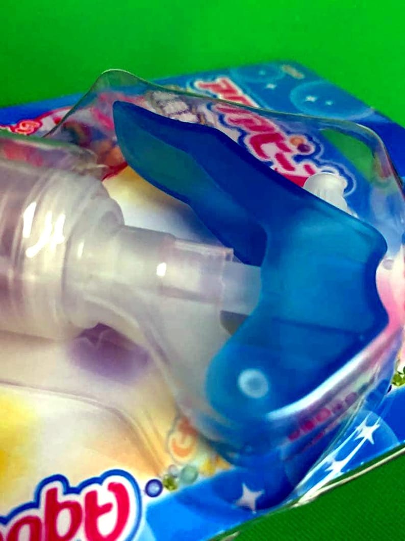 May include: A close-up of a baby bottle with a blue handle and a clear nipple. The bottle is partially visible, with the focus on the blue handle and the packaging. The packaging has a blue and white design with the word "baby" visible.