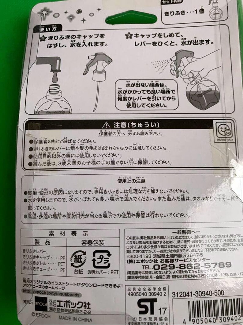 May include: A package with a spray bottle toy, featuring Japanese text and illustrations. The package includes instructions and warnings. The toy is designed for children and includes a clear plastic bottle and a green cap.