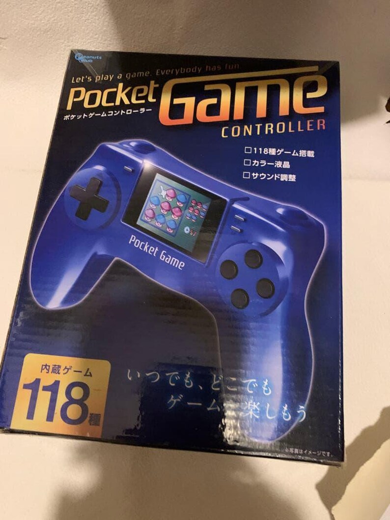 Pode incluir: Uma caixa azul do Pocket Game Controller com o texto "Let's play a game. Everybody has fun." O controlador tem uma tela exibindo um jogo. A caixa tamb&eacute;m tem texto japon&ecirc;s e o n&uacute;mero 118.
