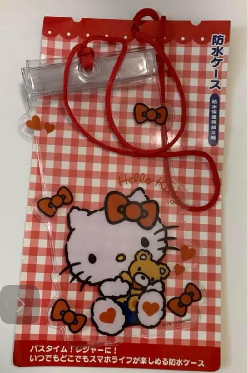 Pode incluir: Capa de telefone &agrave; prova d'&aacute;gua transparente com Hello Kitty segurando um ursinho de pel&uacute;cia, com la&ccedil;os e cora&ccedil;&otilde;es laranja em um fundo xadrez vermelho e branco. Inclui um cord&atilde;o vermelho. O texto na embalagem diz "Hello Kitty" e texto japon&ecirc;s.