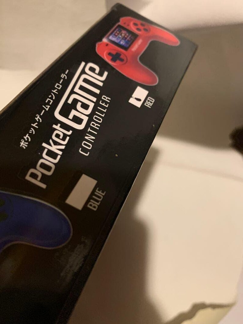 Pode incluir: Caixa preta para um Pocket Game Controller. A caixa apresenta um gr&aacute;fico de controlador vermelho e a palavra "RED" ao lado. A palavra "BLUE" tamb&eacute;m &eacute; vis&iacute;vel. Texto japon&ecirc;s tamb&eacute;m est&aacute; presente.