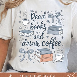 以下が含まれることがあります： 「Read books and drink coffee」と書かれたグラフィックデザインの白いTシャツ。デザインには、本、コーヒーカップ、リボンのイラストが青と桃色で描かれています。「GLOW THREAD DESIGN」の文字が下部にあります。