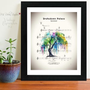 May include: Framed print of sheet music titled "Brokedown Palace" featuring a watercolor painting of a colorful weeping willow tree. The artwork is set against a cream-colored background and framed in a black frame.