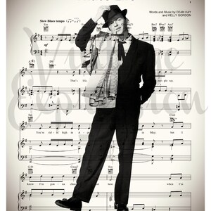 May include: A black and white photo of a man wearing a hat and a scarf, superimposed over sheet music for the song "That's Life". The sheet music includes the lyrics "That's life, people say." and "You're ridin' high in May: but I know I'm gonna change that tune when I'm..."