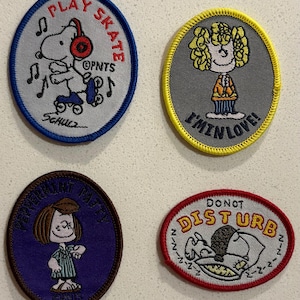 Może przedstawiać: Cztery haftowane naszywki z postaciami z Peanuts. Jedna przedstawia Snoopy'ego na rolkach z napisem "Play Skate". Inna przedstawia dziewczynę z napisem "I'm in love!". Trzecia naszywka przedstawia Peppermint Patty. Ostatnia przedstawia Snoopy'ego śpiącego z napisem "Do Not Disturb".