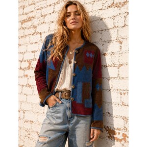 Puede incluir: Una chaqueta de manga larga con botones y diseño de patchwork en tonos azul oscuro, burdeos y marrón. La chaqueta presenta un cuello redondo, un cierre frontal con botones metálicos y un acabado texturizado sobre una blusa blanca.