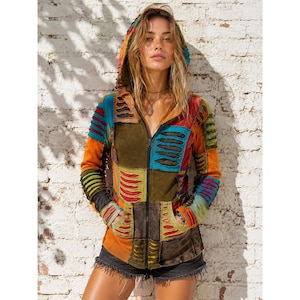 May include: A long-sleeve zip-up hoodie featuring a patchwork design in shades of orange, blue, green, and brown. The garment includes a hood, two front pockets, and horizontal distressed cut-out details across the sleeves and torso panels.