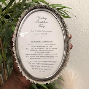 May include: Oval silver-toned wedding invitation tray with a decorative lace edge. The tray has text that reads "Wedding Invitation Tray" and "Your Wedding Announcement preserved for life!" Instructions for mounting are also included.