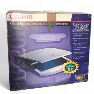 Puede incluir: Caja del escáner de sobremesa Canon CanoScan FB 620P. La caja es una mezcla de azul, blanco y rojo, con la imagen del escáner y texto. Incluye escaneo en color de alta calidad, diseño elegante y configuración sencilla.