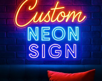May include: A neon sign with the words "Custom NEON SIGN" in bright, glowing colors against a dark brick wall. A red pillow rests on a blue couch below the sign.