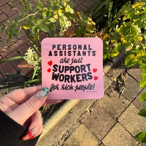 May include: A square pink sticker with rounded corners featuring black text that reads: PERSONAL ASSISTANTS are just SUPPORT WORKERS for rich people! The design includes small red hearts scattered around the text and a small hashtag at the bottom.