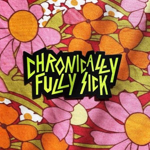 Puede incluir: Una pegatina negra y amarilla con el texto "Chronically Fully Sick" en una fuente en negrita y estilizada.