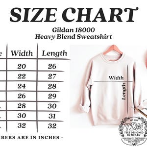 K&ouml;nnte beinhalten: Gr&ouml;&szlig;entabelle f&uuml;r Gildan 18000 Heavy Blend Sweatshirts, mit Ma&szlig;en in Zoll. Die Tabelle umfasst die Gr&ouml;&szlig;en S bis 4XL mit den entsprechenden Breiten- und L&auml;ngenma&szlig;en. Ein hellrosa Sweatshirt h&auml;ngt an einem Kleiderb&uuml;gel, mit einem rosa Hut im Hintergrund.