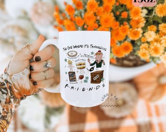 Può includere: Tazza in ceramica bianca da 15 once con la scritta "THE ONE WHERE IT'S THANKSGIVING" e varie illustrazioni. La tazza ha un manico ed è decorata con immagini di una torta, un pallone da football e altri elementi a tema Thanksgiving. La parola "FRIENDS" è in basso.