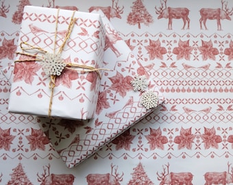 May include: Two wrapped gifts with white and red patterned paper, tied with twine and a snowflake ornament. The wrapping paper features a repeating design of birds, reindeer, Christmas trees, and poinsettias. The gifts are on a matching roll of paper.