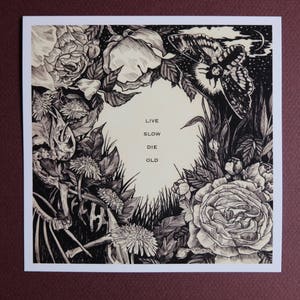 May include: Black and white illustration of flowers, leaves, and a butterfly with the text "Live Slow Die Old" printed in the centre.