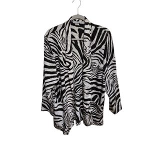 May include: A black and white zebra print cardigan hanging on a gray hanger. The open-front cardigan has long sleeves and two front pockets. The fabric has a textured appearance.