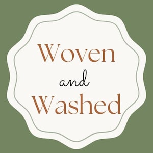 May include: A logo with the words "Woven and Washed" in a serif font. The text is in a warm brown color, set against a cream-colored, scalloped shape. The background is a muted green.