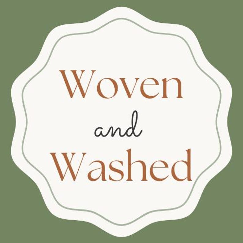 May include: A logo with the words "Woven and Washed" in a serif font. The text is in a warm brown color, set against a cream-colored, scalloped shape. The background is a muted green.