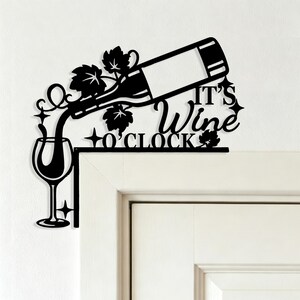 May include: A black metal corner wall sign featuring a wine bottle pouring into a glass, decorated with grape leaves and star accents. The text reads IT'S Wine O'CLOCK. The design is shaped to fit around the corner of a door frame or wall edge.