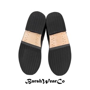 May include: A pair of black leather shoes, soles up, with a textured rubber sole and visible stitching. The brand name "BarshWearCo" is printed at the bottom. The shoes are set against a white background.