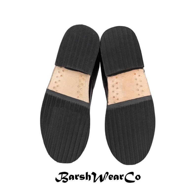 May include: A pair of black leather shoes, soles up, with a textured rubber sole and visible stitching. The brand name "BarshWearCo" is printed at the bottom. The shoes are set against a white background.