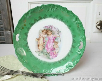 probably Wedgwood Small round green china plate with antique decor of a woman with angel