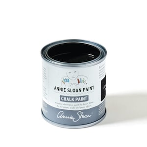 Könnte beinhalten: Eine schwarze Dose Annie Sloan Chalk Paint. Die Dose hat ein weißes Etikett mit dem Annie Sloan Logo und dem Text "Chalk Paint" und "Eine einzigartige Dekorationsfarbe von Annie Sloan für Möbel, Wände und Farbeffekte".