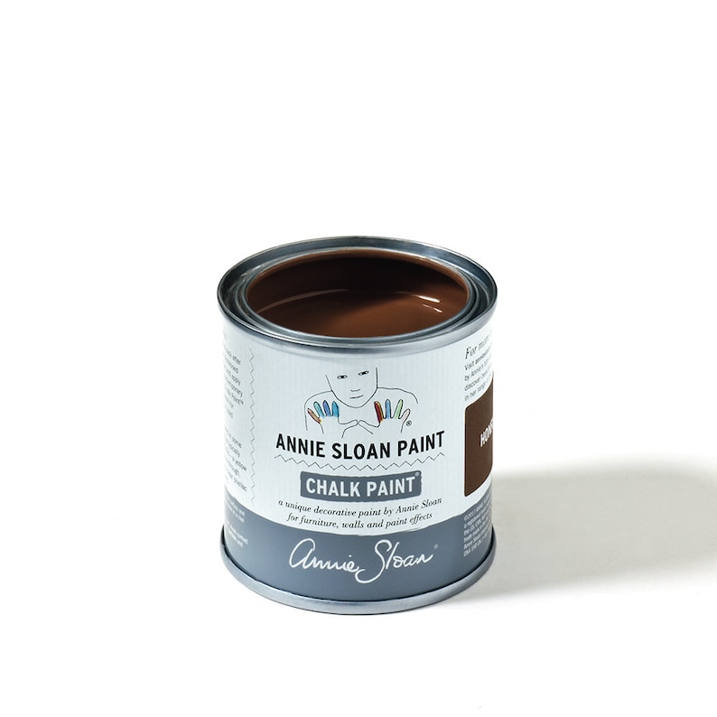 K&ouml;nnte beinhalten: Eine braune Farbdose mit dem Etikett "Annie Sloan Paint Chalk Paint" und dem Text "eine einzigartige Dekorationsfarbe von Annie Sloan f&uuml;r M&ouml;bel, W&auml;nde und Farbeffekte". Das Etikett enth&auml;lt auch die Unterschrift "Annie Sloan".