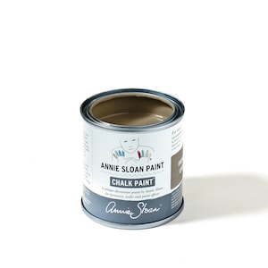 以下が含まれることがあります： フランスリネンカラーのアンニースローンチョークペイント缶。缶は薄い茶色で、白いラベルには「アンニースローンチョークペイント」と「家具、壁、ペイントエフェクトに最適なアンニースローンのユニークな装飾用ペイント」と書いてあります。