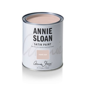 May include: A can of Annie Sloan Satin Paint in the color Pointe Silk. The can is white with black lettering and a pink lid. The paint is for interior wood and metal and is 25 US fl oz / 750 ml.