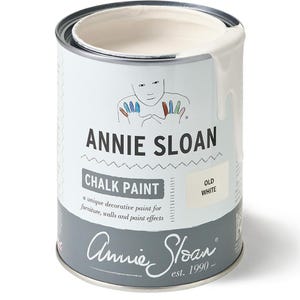 May include: A can of Annie Sloan Chalk Paint in Old White. The can is white with a gray base and features the brand name and a drawing of a face with colorful hands. The paint is designed for furniture, walls, and paint effects.
