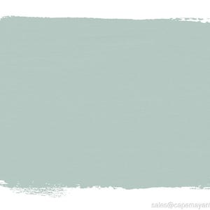 May include: A rectangular swatch of pale blue-green paint with visible brushstrokes and a textured appearance. The edges of the paint are uneven, suggesting a hand-painted application. The background is white.