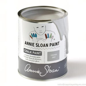 May include: A can of Annie Sloan Chalk Paint in Chicago Grey. The can has a white label with the brand name and a drawing of a person with colorful fingers. The paint is dripping down the side.