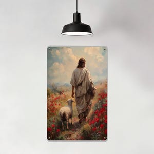May include: Metal sign featuring a painting of a figure in white robes walking with a lamb through a field of red flowers. The background shows a cloudy sky and rolling hills. The sign is rectangular with rounded corners.