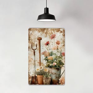 May include: A rectangular metal sign with a distressed, vintage aesthetic. It features a rustic garden scene with a shovel, a pitchfork, and a galvanized bucket overflowing with pink and yellow flowers. The background has a weathered, aged appearance.
