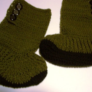 May include: A pair of green crocheted boot cuffs with black trim and black buttons.