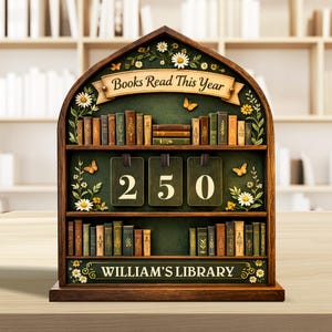 以下が含まれることがあります： 「Books Read This Year」と「William's Library」の文字が入った、本棚型の木製ディスプレイ。 ディスプレイには「250」の数字がぶら下がったタグに表示されています。 棚にはミニチュアの本、蝶、花のアクセントが並んでいます。