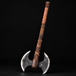 May include: A double-bitted axe featuring a weathered, dark metallic head with two curved blades. The long, cylindrical handle is crafted from textured brown wood, reinforced with crisscrossing leather straps along the shaft and grip.