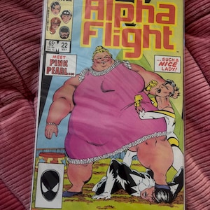 Peut inclure: Couverture de la bande dessinée Alpha Flight #22. On y voit une femme corpulente en robe rose et une super-héroïne en costume blanc et jaune. La couverture porte le logo Marvel et les textes "MEET PINK PEARL..." et "...SUCH A NICE LADY!"
