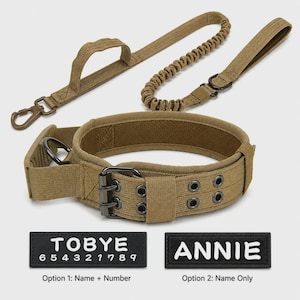 May include: A tan tactical dog collar with a double-prong metal buckle and a matching bungee leash featuring a control handle. Two rectangular black patches are included: one with the text TOBYE 6 5 4 3 2 1 7 8 9 and one with ANNIE.