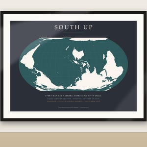 Könnte beinhalten: Ein gerahmter Wandkunstdruck mit einer nach Süden ausgerichteten Weltkarte in Weiß auf dunkelblaugrünem Hintergrund. Der Text lautet SOUTH UP, EVERY MAP HAS A CENTRE. THERE IS NO UP IN SPACE. EQUAL EARTH PROJECTION - SOUTH UP - CENTRED ON 150°E.