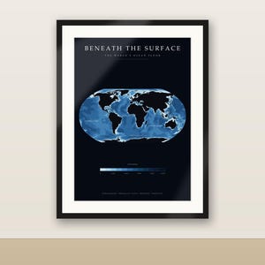 May include: A framed wall art print titled BENEATH THE SURFACE THE WORLD'S OCEAN FLOOR. The dark navy poster features a central oval map showing global bathymetry in shades of blue, with black landmasses and a depth scale at the bottom.