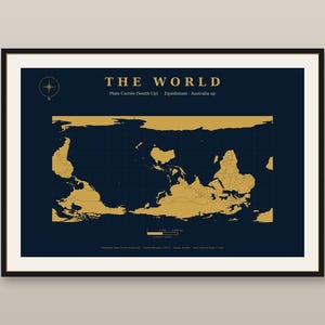Könnte beinhalten: Eine gerahmte Wandkarte mit dem Titel THE WORLD, die einen dunkelblauen Hintergrund mit goldfarbenen Kontinenten zeigt. Die Karte verwendet eine Plate-Carrée-Projektion mit nach oben ausgerichteter Australien. Ein Kompass ist oben links.