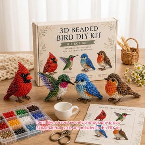 Puede incluir: Un kit de manualidades de pájaros con cuentas 3D en una caja etiquetada 3D BEADED BIRD DIY KIT 4-PIECE SET. Incluye cuatro figuras de pájaros terminadas: un cardenal rojo, un colibrí verde, un pájaro azul y un petirrojo marrón, más cuentas.