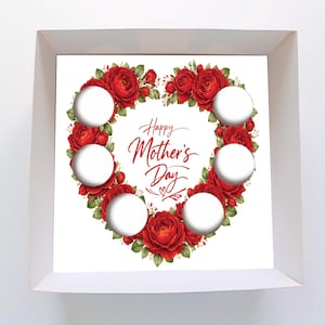Op de afbeelding: Een witte doos met een bloemenontwerp voor Moederdag. Het ontwerp heeft een hartvormige krans van rode rozen rond de tekst "Happy Mother's Day". Er zijn zes cirkelvormige uitsparingen in het ontwerp.