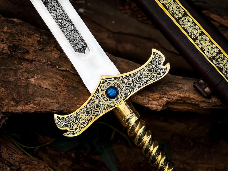 May include: A detailed close-up of a decorative sword with a silver blade and ornate gold hilt. The hilt features a blue gem and intricate patterns. A brown leather sheath with gold accents is visible in the background.