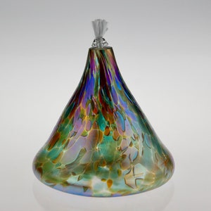 May include: A glass oil lamp with a iridescent finish. The lamp has a wide base and a narrow neck with a white wick.