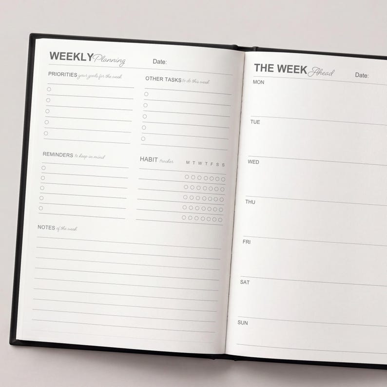 May include: Open black notebook with a weekly planning layout. The left page includes sections for priorities, other tasks, reminders, and notes. The right page is for daily scheduling, with spaces for each day of the week.
